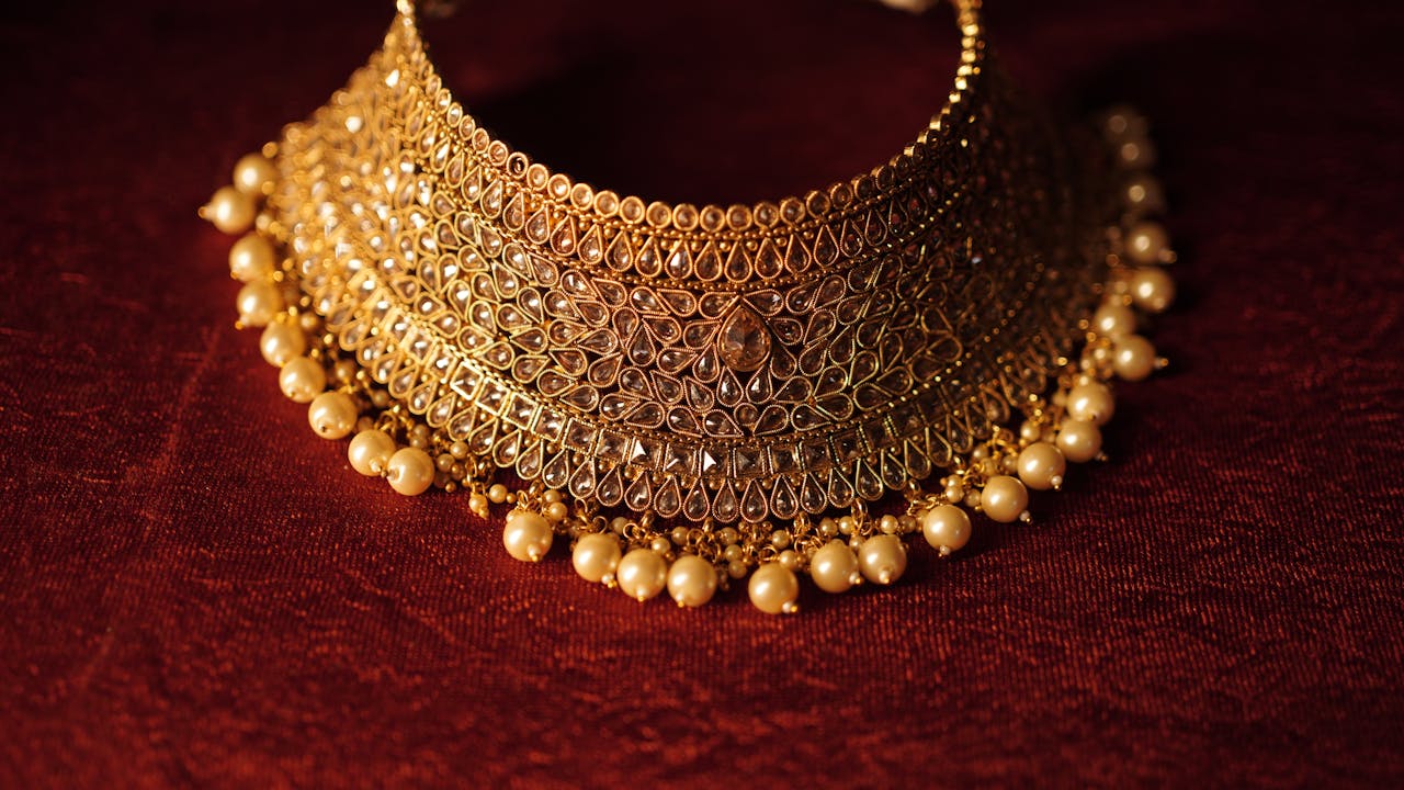 Crafting Captivating Headlines: Your awesome post title goes here Elegant gold necklace with pearls on a rich red background, showcasing fine craftsmanship.
